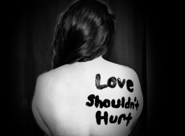 love shouldn't hurt-printed on back of woman