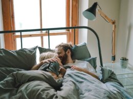 man kissing woman on her forehead