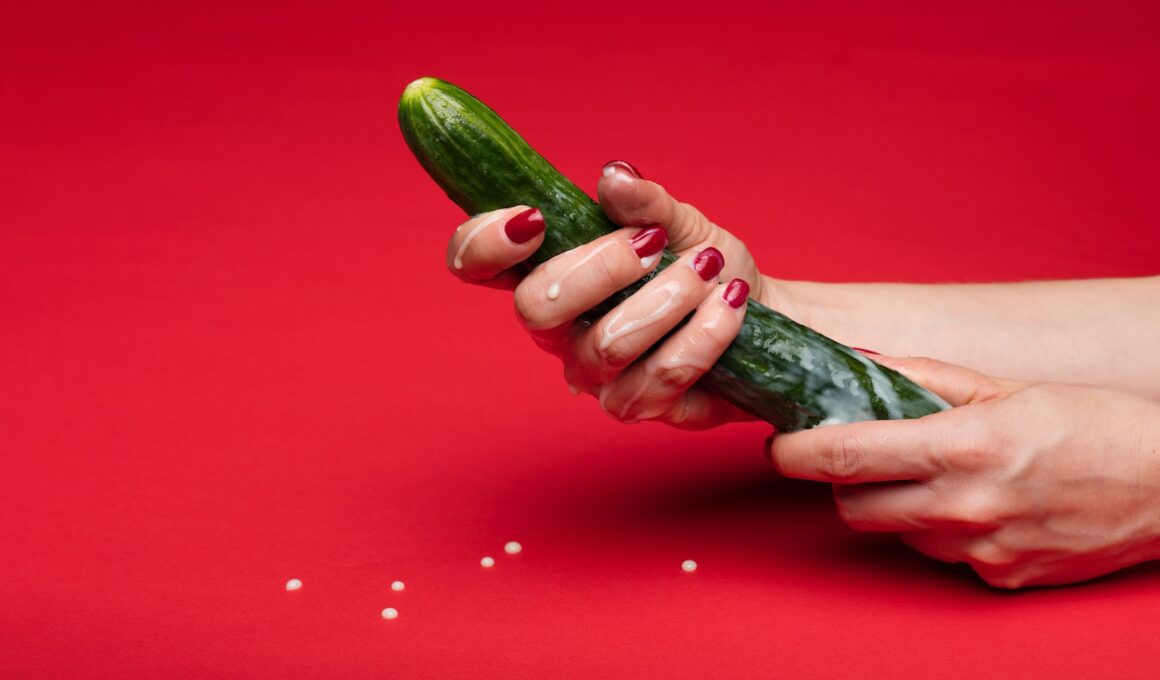 person holding green cucumber on red table