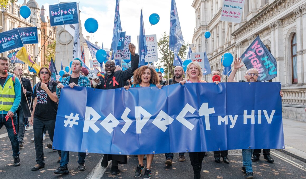 a group of people marching down a street holding a sign