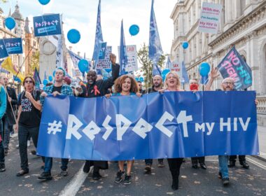 a group of people marching down a street holding a sign