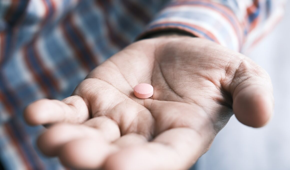 person holding pink round medication pill