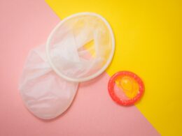 red condom on pink and yellow surface