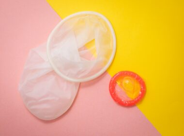 red condom on pink and yellow surface