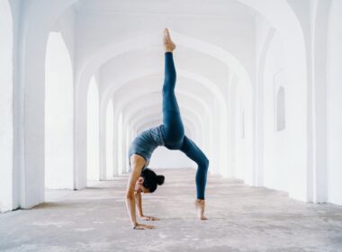 woman in blue leggings and black tank top doing yoga